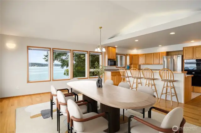 Looking back toward the kitchen from the dining room. There is a double wall oven, French door refrigerator, 5 burner cooktop, dishwasher and a microwave.