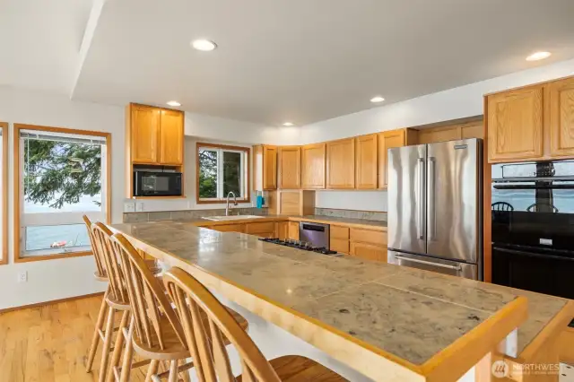 The kitchen has a large island with a 4-seat eating bar and a 5-burner gas cooktop.