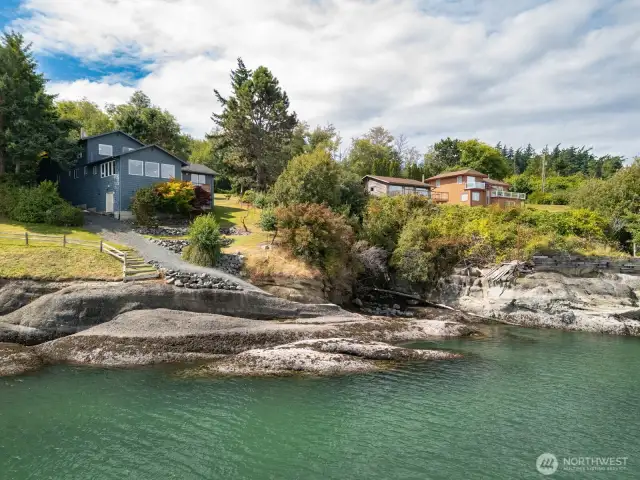 View of the home and beach below, from the water.