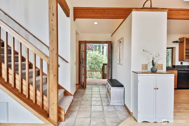 Looking back at the front entry. Stairs lead to the Upper Level Primary Suite. Kitchen and Dining Area are to your right and the Living Room is to your left.
