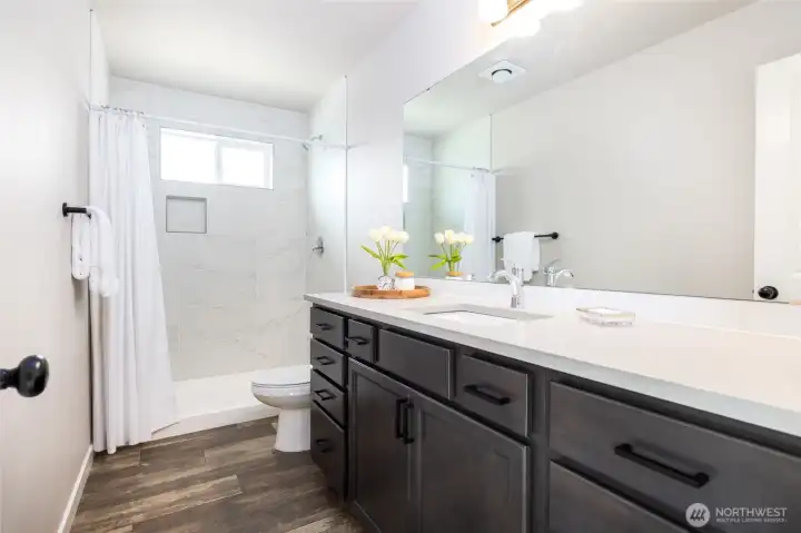 Spacious counter and tile shower in the primary bath