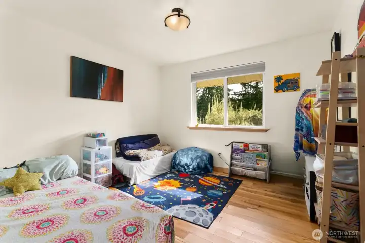 The third bedroom looks out to the forested back lot.