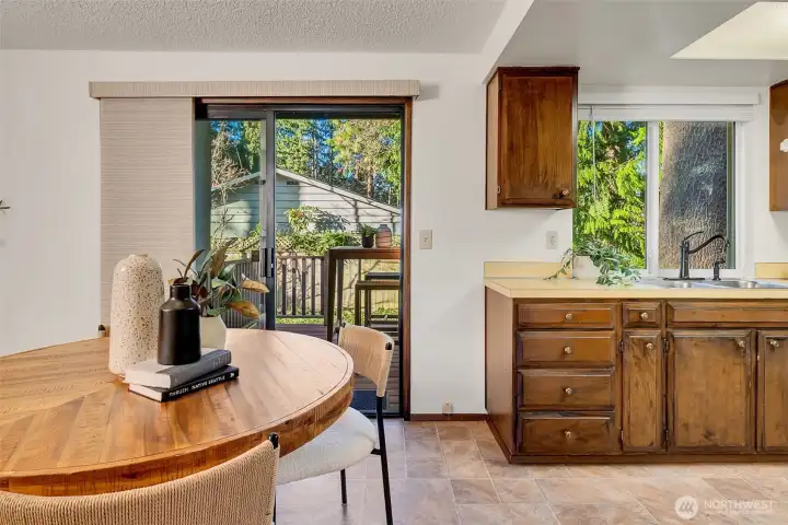 The kitchen has a cozy eating area and sliders to a lovely backyard deck.
