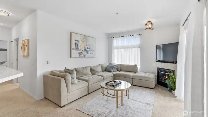 Cozy up by the fireplace in this bright and inviting living room filled with natural light.