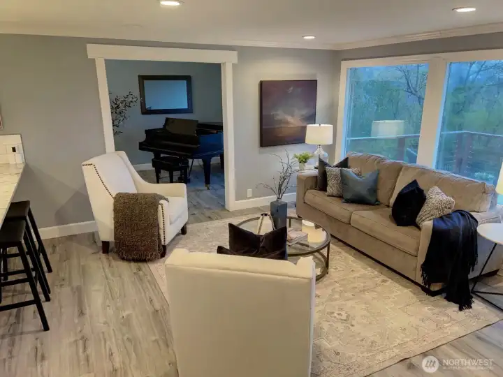 View of living room with piano room in background.