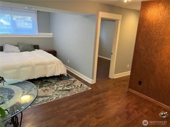 Lower level living space. The doorway to the right is to the 4th bedroom. The hallway leads to a bathroom and office, a large laundry room and the garage entrance. Lower level living space. The doorway to the right is to the 4th bedroom. The hallway leads to a bathroom and office, a large laundry room and the garage entrance.