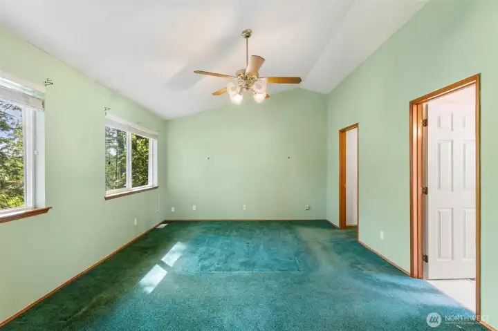Primary bedroom with a walk in closet and 5 piece bath