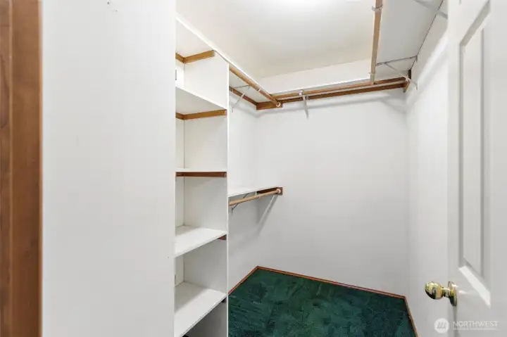 Huge walk in closet for primary bedroom. How many pairs of shoes can you fit on those shelves?