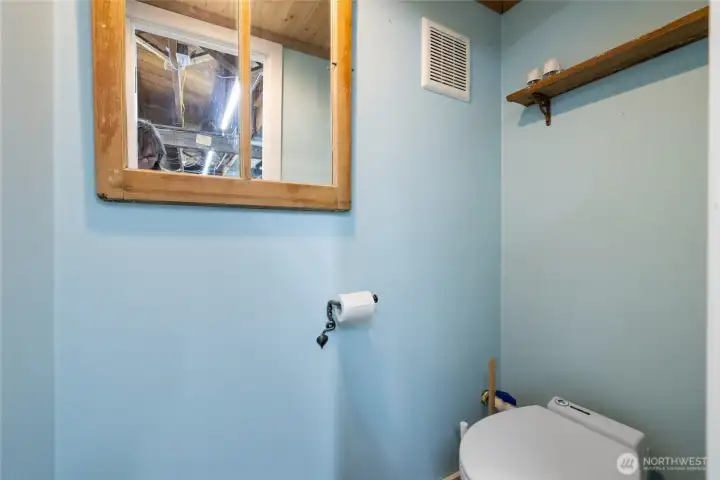 Water closet next to laundry area.