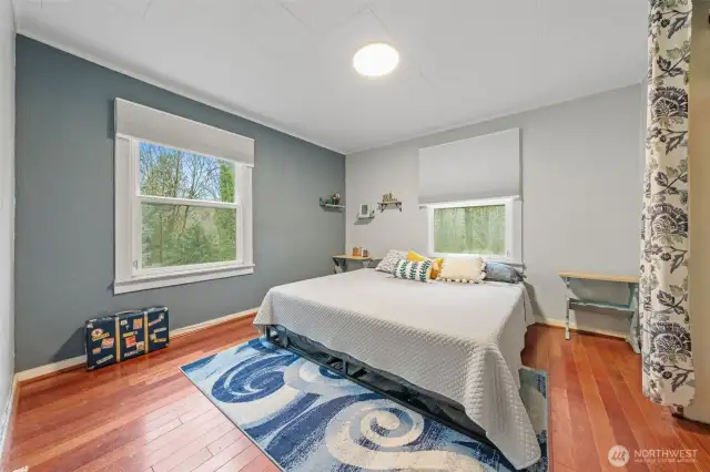 Primary with hardwood floors & large windows.