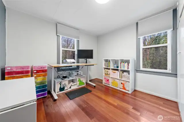 Bedroom with hardwood floors and lots of natural light coming through.