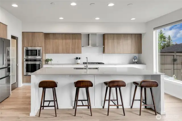 Gleaming quartz countertops, glass backsplash and an abundance of beautiful white cabinetry wrap around the kitchen, for maximum use of space.  High-quality Electrolux appliances highlight the kitchen, including a gas cooktop.