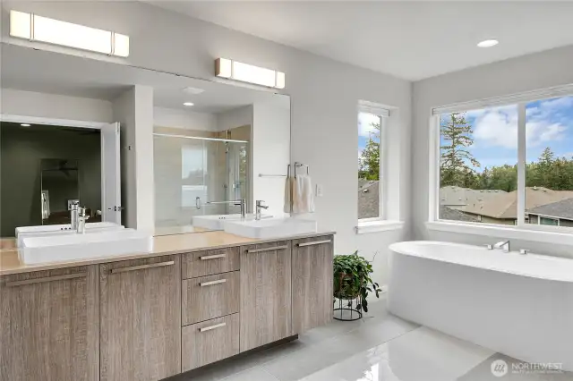 The extra-long vanity is topped with two raised square sinks.  A window fills this bathroom with natural light and the toilet is located in a separate room for privacy.