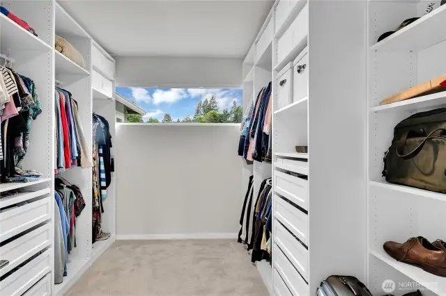 A spacious walk-in closet with lots of high-quality organizers is located off the primary bath. In this closet there are multiple drawers, shelves and clothes hanging sections.  Plus there is a long window that lets in natural light.