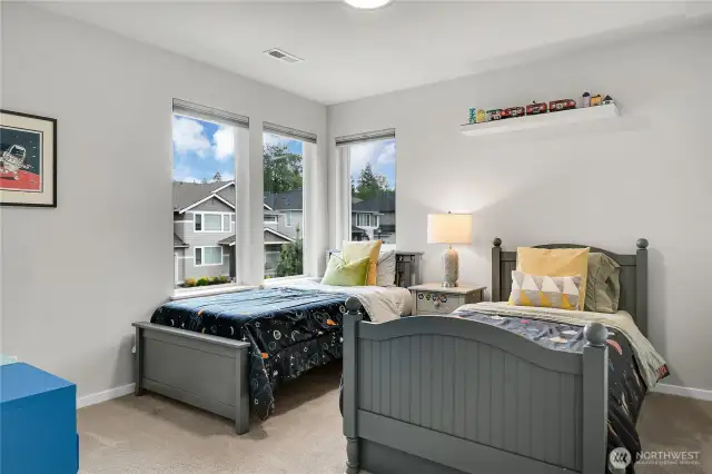 Bedroom two has a walk-in closet, a long window overlooking the side yard and two additional long windows overlooking the front yard.