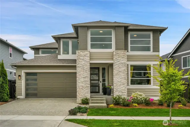 Large garage with the upgraded pedestrian-door leading outside.    Upgraded with the holiday lighting package, with exterior outlets in the eaves.