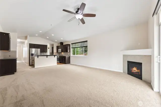Great room concept with vaulted ceilings, fireplace open to Kitchen