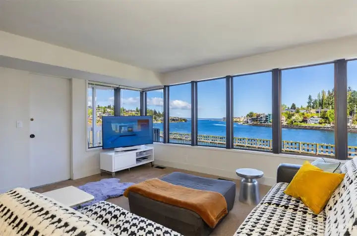 Lower level living room also features a window wall, door opens to private deck.