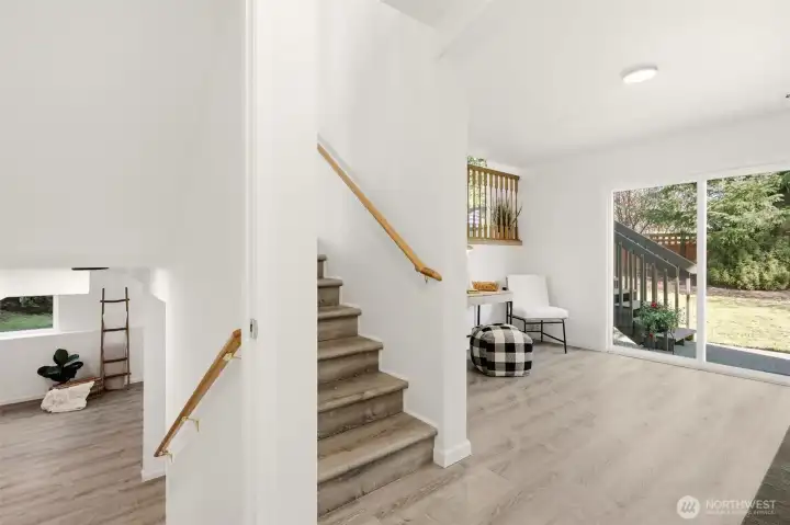 Upper stairs take you to the kitchen and dining area. The lower stairs lead to the spacious flex space offering many possibilities.