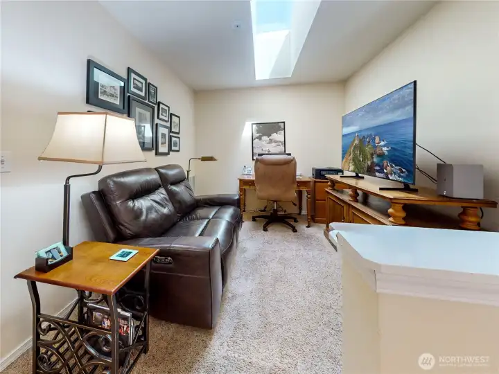 Versatile upstairs loft space with a bright skylight is perfect for a home office, playroom, media space, or home gym.