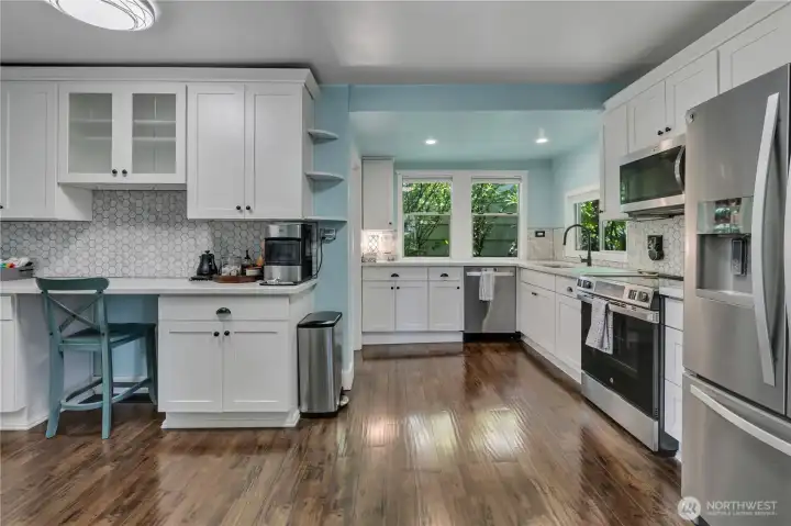 White cabinetry, quartz counters, and tile backsplash