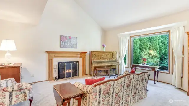 Front room features cozy wood burning fireplace and bay windows.