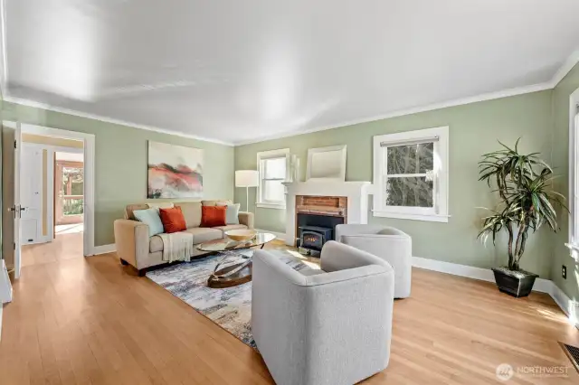Bright and welcoming living room showcases beautiful Fir hardwood floors and timeless architectural charm. The thoughtful layout offers ample space for both everyday lounging and effortless entertaining.