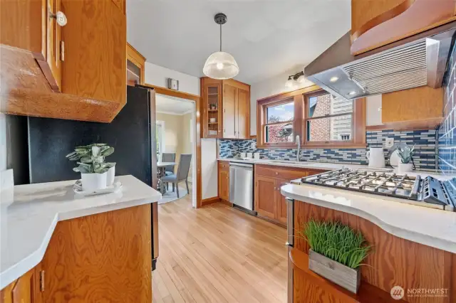 A bright and inviting kitchen features solid wood cabinetry, sleek quartz countertops, and a stylish tile backsplash that adds a pop of color and character.