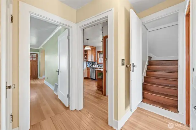 This central hallway offers seamless access to the living room, kitchen, two main-level bedrooms, full bathroom, and a staircase leading to the upper-level Primary Suite