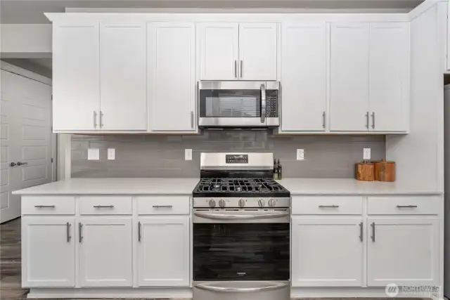 White cabinetry with quartz countertops.