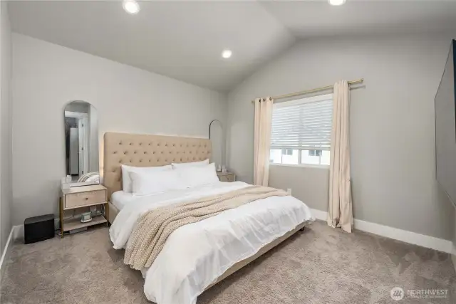 Vaulted ceiling in spacious primary bedroom.