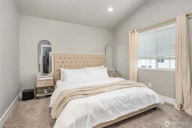 Vaulted ceiling in spacious primary bedroom.