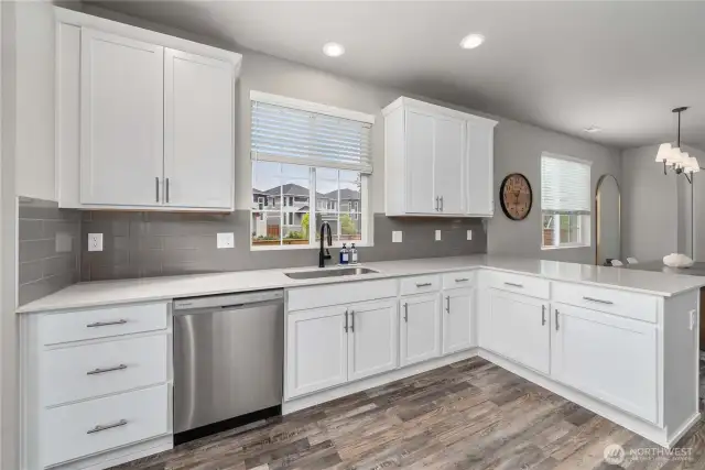 White cabinetry with quartz countertops.