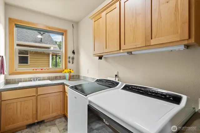 Spacious laundry/utility room with sink and ample cabinet space
