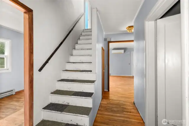 Hall leading into living room. Den on left. Bathroom on right.