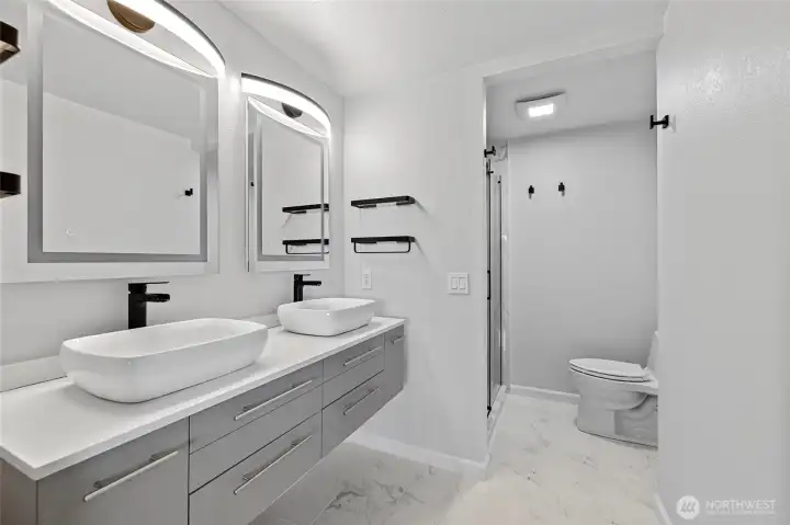 Primary bath is complete with double vanities and tile walk-in shower