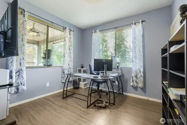 Spacious and bright main-level den or office featuring oversized windows with serene views of the private yard.