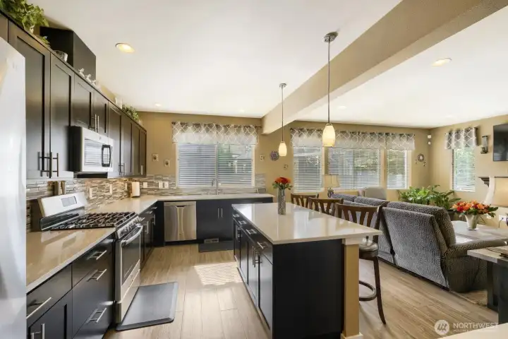 High-efficiency kitchen featuring a gas stove, center island, abundant cabinetry for storage, sleek quartz countertops, and tasteful modern accents.
