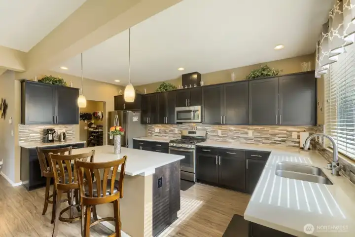 Stainless steel appliances, an under-mount sink, and a spacious island with seating create a stylish and functional kitchen ideal for everyday living and entertaining.