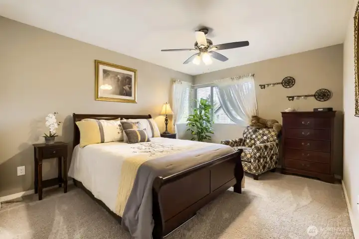3rd upper-level oversized bedroom featuring plush carpeting, a corner window for added natural light, a ceiling fan, and plenty of space to make it your own.