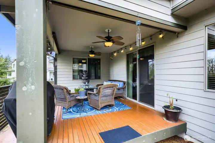 Private rear deck overlooking a serene greenbelt, complete with ceiling fans and accent lighting—perfect for relaxing with a good book, enjoying a glass of wine, or hosting summer BBQs.