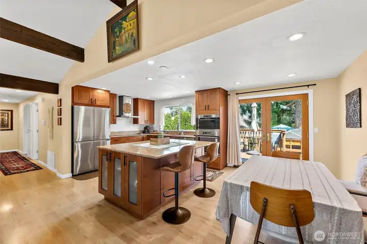 The heart of the home, just off the family room is this classic and timeless kitchen offers a welcoming breakfast bar, dining area and French doors leading to the deck for easy BBQ'ing.