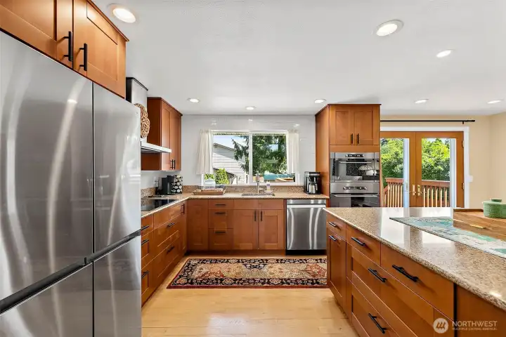 Stunning updated kitchen with sleek stainless steel appliances, a deep undermount sink, soft close cabinets, granite countertops, and a timeless subway tile backsplash.