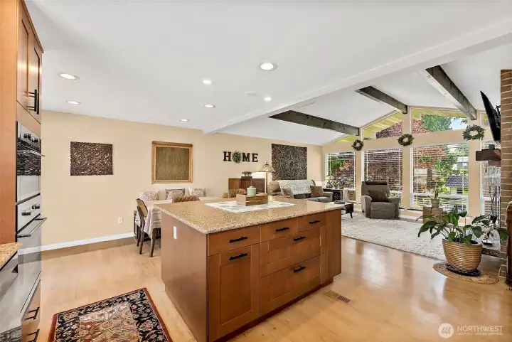 Large kitchen breakfast bar with granite countertops and storage on two sides- true center of the kitchen and family room makes this area perfect for entertaining.