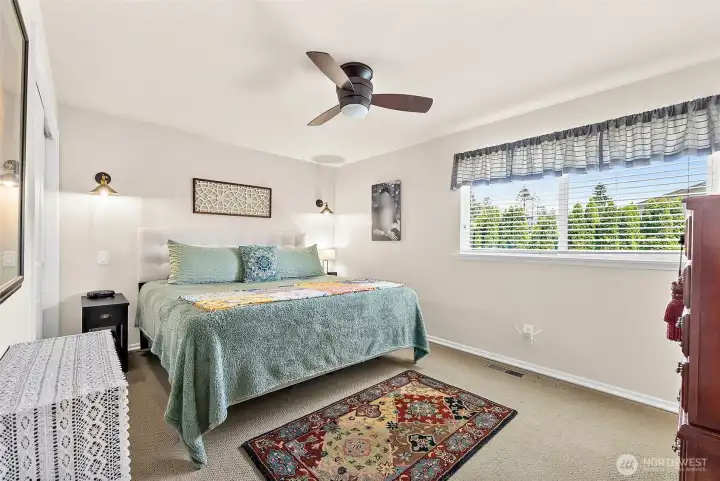 Primary suite with windows over looking the pool area, wall scones for the evening readers and a ceiling fan to complete this room.