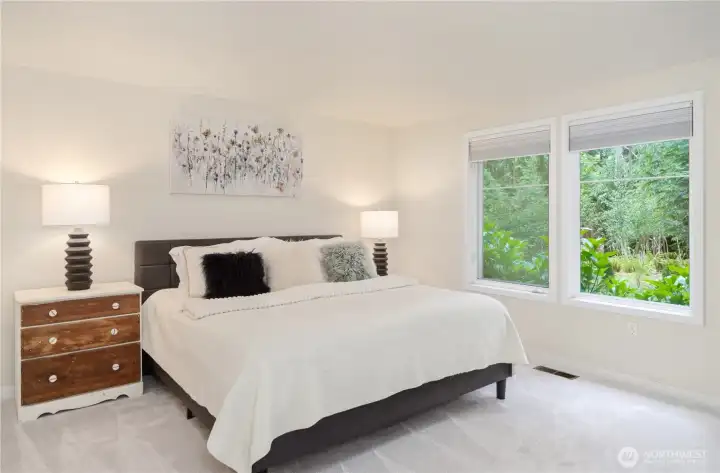 Spacious primary suite with new carpet with windows to the serence view. Spacious primary suite with new carpet with windows to the serence view.