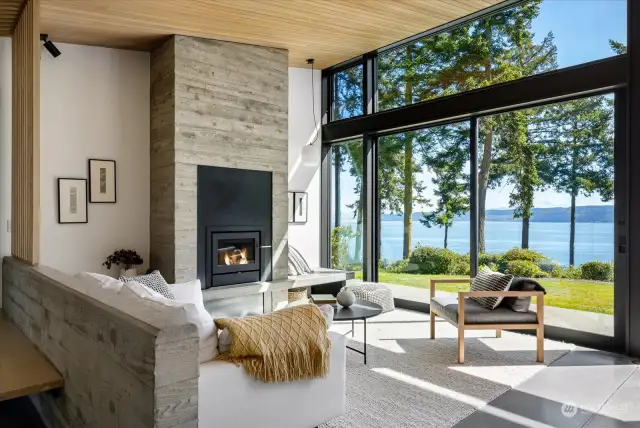 Living room features a concrete and steel fireplace, and stunning water views.