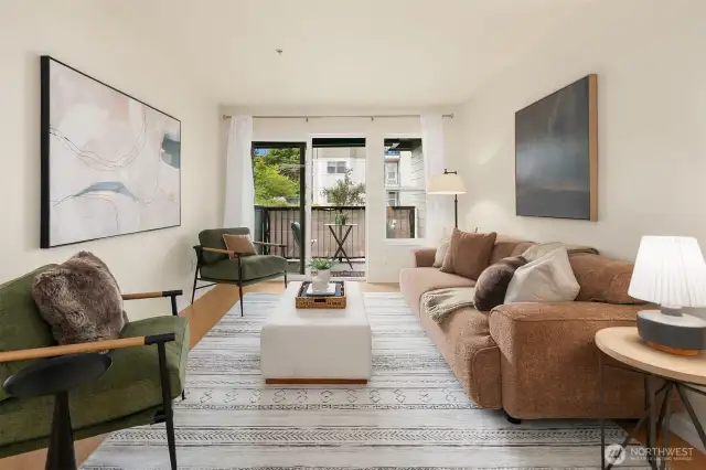 Living area features a wall of windows and slider opening up to deck