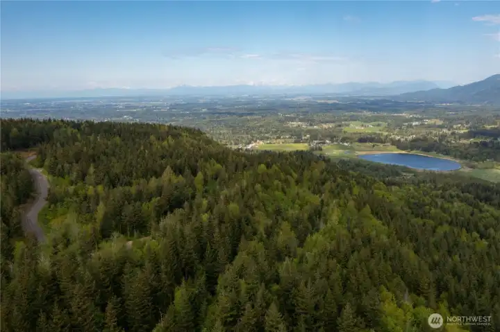 Aerial View looking at Squalicum Lake, Valley, with the Canadian Coastal Mountain range in the distance