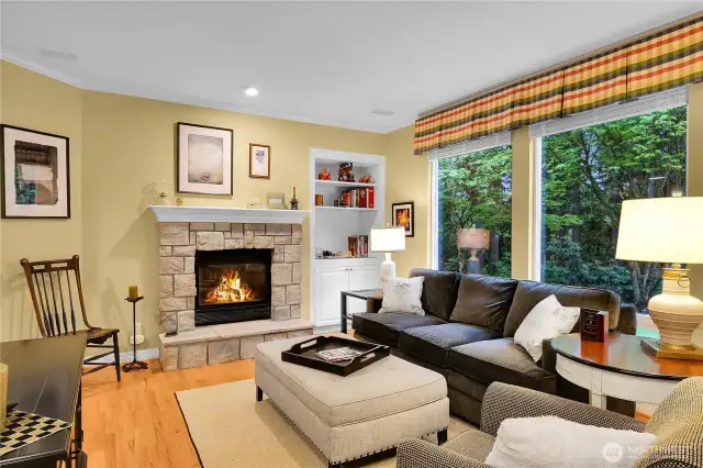 Family room. 9-foot ceiling with crown moulding, built-in speakers. Oversized windows look out to private yard, forested park behind. English Castle Stone gas-log fireplace with raised hearth, built-in bookcase with paneled cabinet. Oak-hardwood floor.